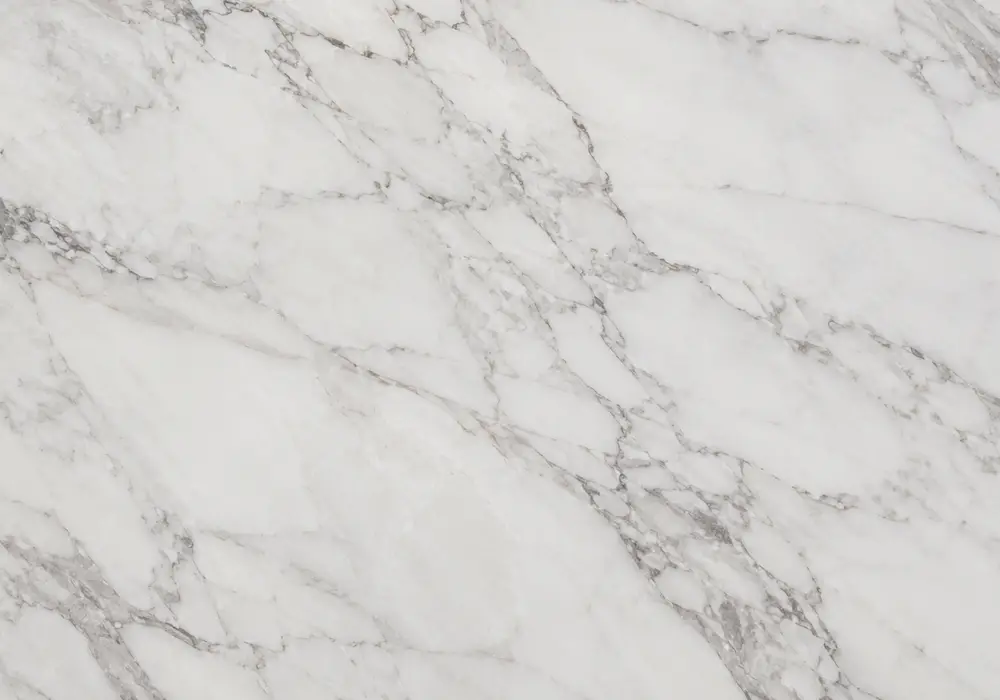 A full-slab view for Agaria marble, revealing white and grey, mineral patches and natural veining, across a luminous surface.