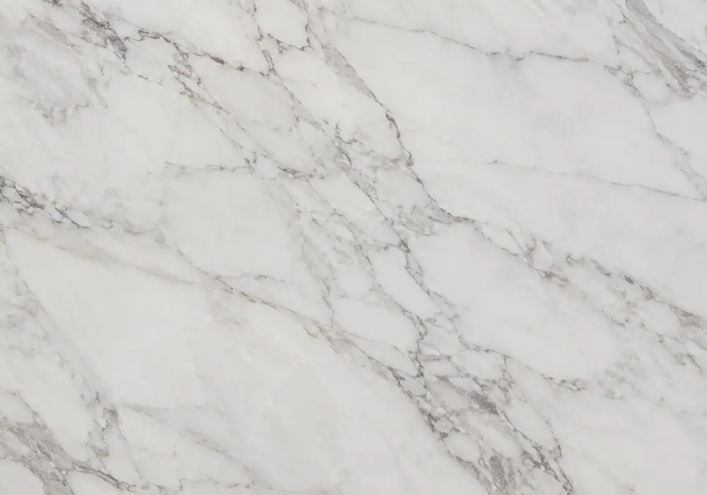 Ariston Crystal White on a polished kitchen countertop and vanity beside honed samples with fine crystalline grey veining.