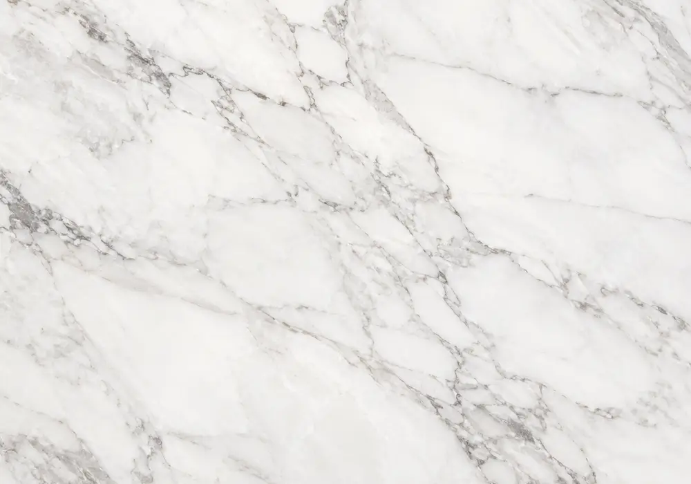 Carrara slab whiteness grading shown with polished vanity, honed shower wall and samples from clean white to greyer grades.