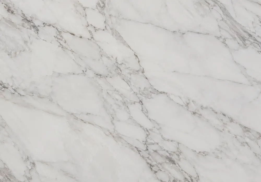 Bianco V marble shown on a polished white and grey slab with clouded movement and natural veining, across a luminous surface.