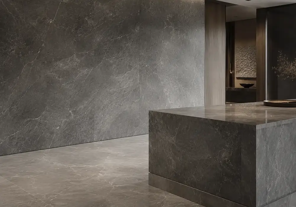Breccia Grey countertop backed by polished slabs and honed samples with irregular white, black, pink and beige fragments.