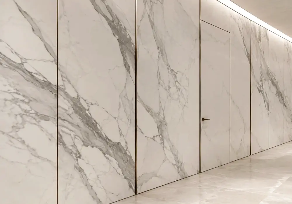 Calacatta Greek Marble console tabletop in a premium stone showroom with upright slabs and refined interior finishes