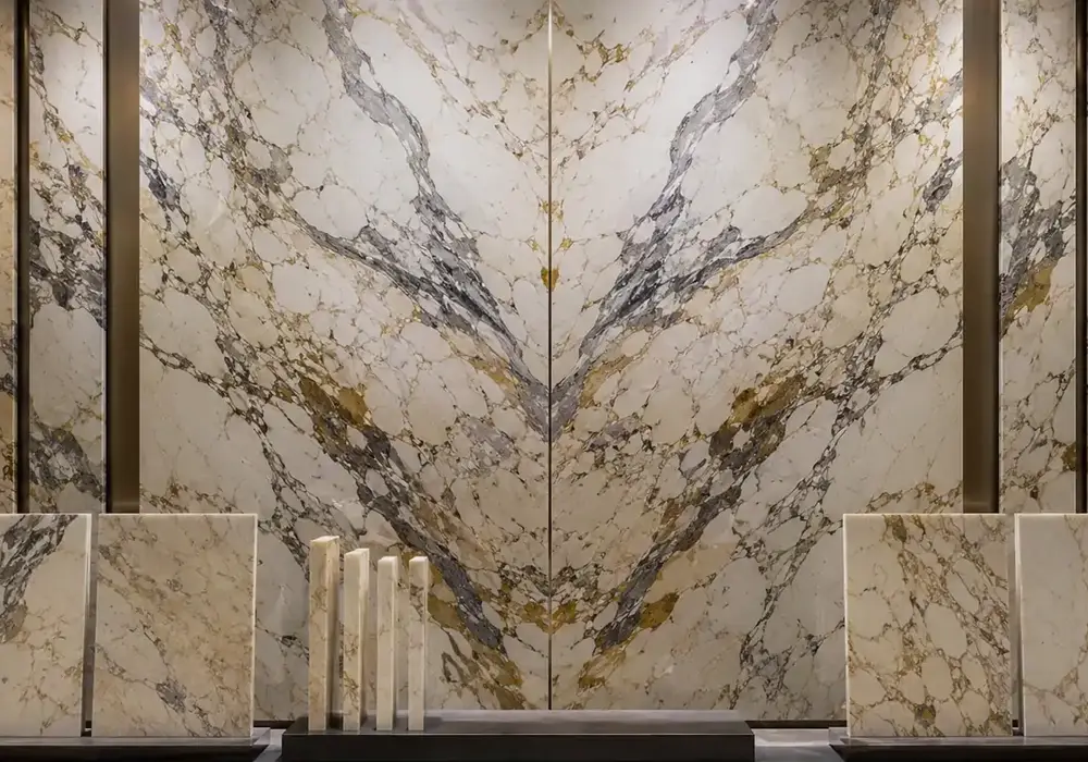 Calacatta Macchia Vecchia marble bookmatched wall with creamy white stone and dramatic grey, gold and warm veining.