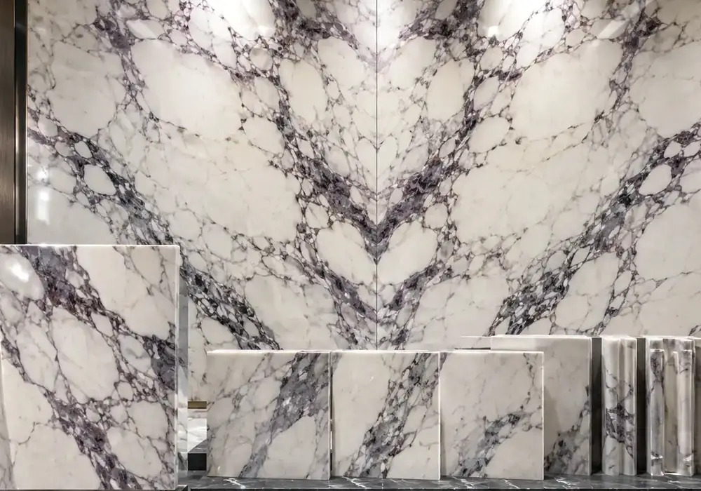 Burgundy breccias cut through ivory Calacatta Viola Marble, revealing bold jewel-like Italian purple-vein marble character.