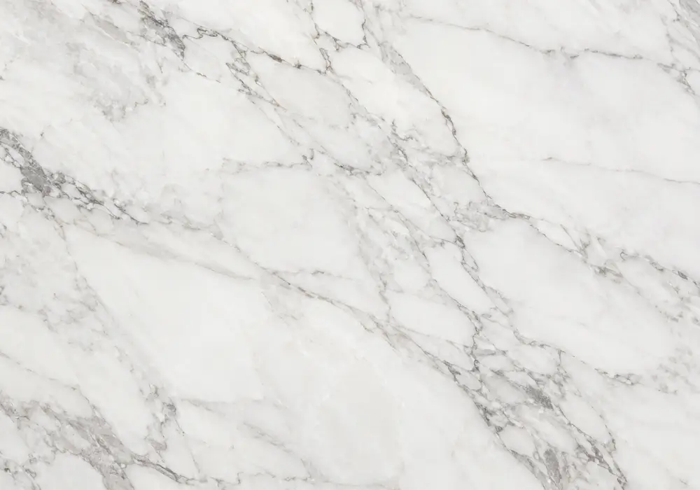 Warm crema marble slab with ivory-beige colouring, subtle caramel veins, fossil traces and softly polished mineral depth.