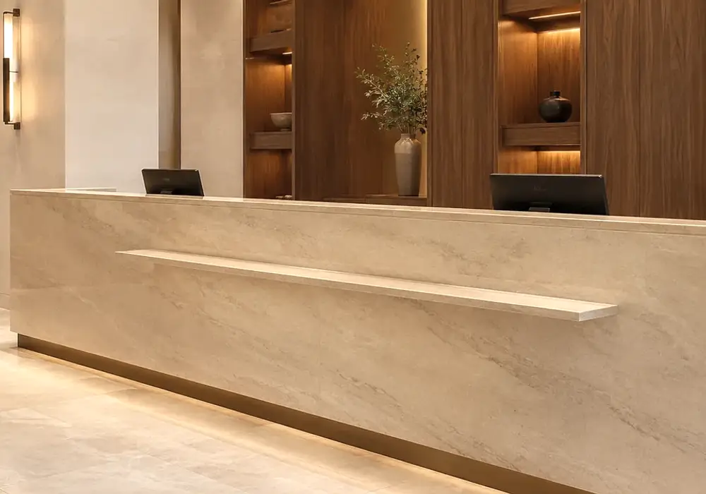 polished cream finish at an indoor threshold beside honed patio paving, steps and low walls in a shaded warm-climate setting.