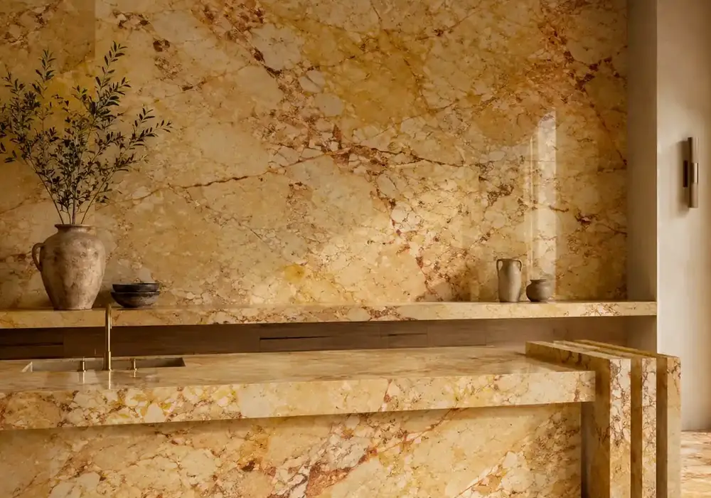 Crema Valencia marble statement lobby wall with warm cream-gold stone and expressive beige and brown veining.