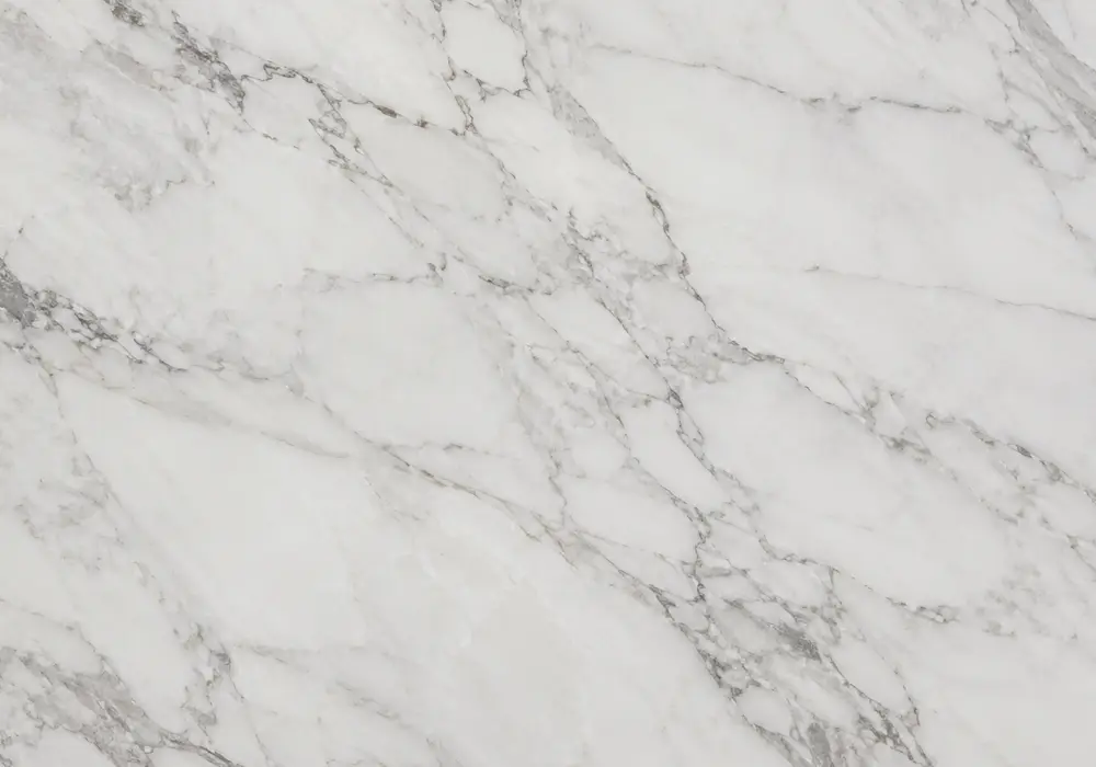 Warm Daino Beige marble slab with ivory, sand and hazelnut tones, soft layered cream-brown waves and fossil-rich detail.
