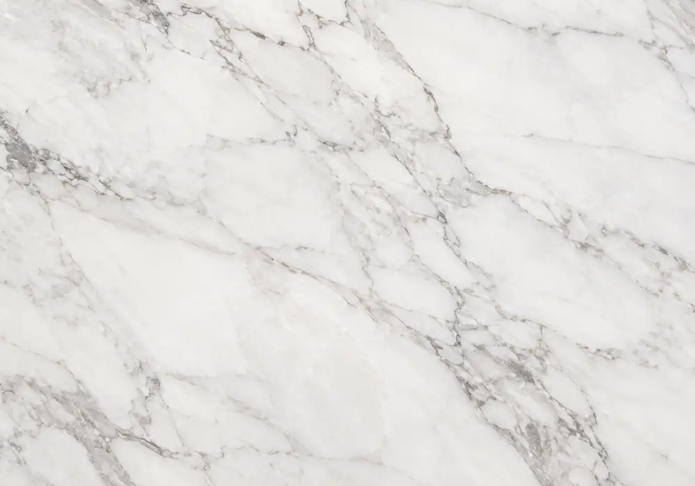 cream calcite veining crosses a mocha reception surface, honed wall panels and fireplace in a warm Gulf hospitality interior.