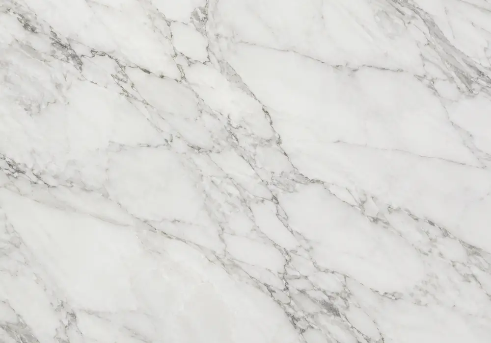 Calacatta Oro stone shown among warm gold, white-gold and black-gold slabs with tiles and fabrication-ready UAE slab stock.