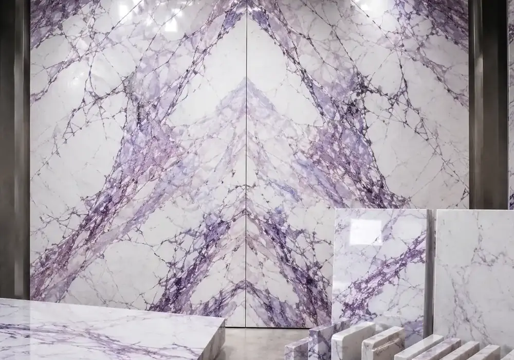 elegant white decorative stone across a statement wall, flooring and an island countertop, with authentic slab variation.