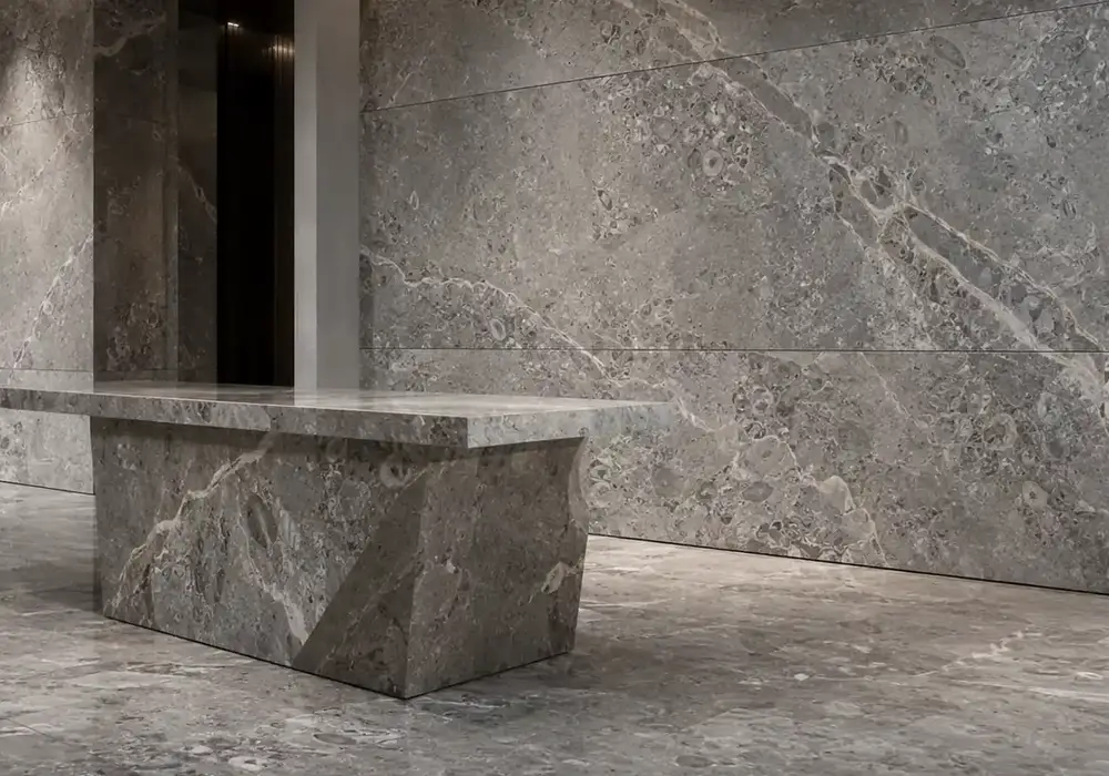 sophisticated grey feature stone across wall cladding, large-format flooring and a countertop, with authentic slab variation.