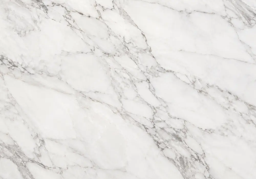 Pentelic vs Carrara on façade, sculpture and countertop, comparing warm creamy Greek stone with a cooler grey-veined slab.