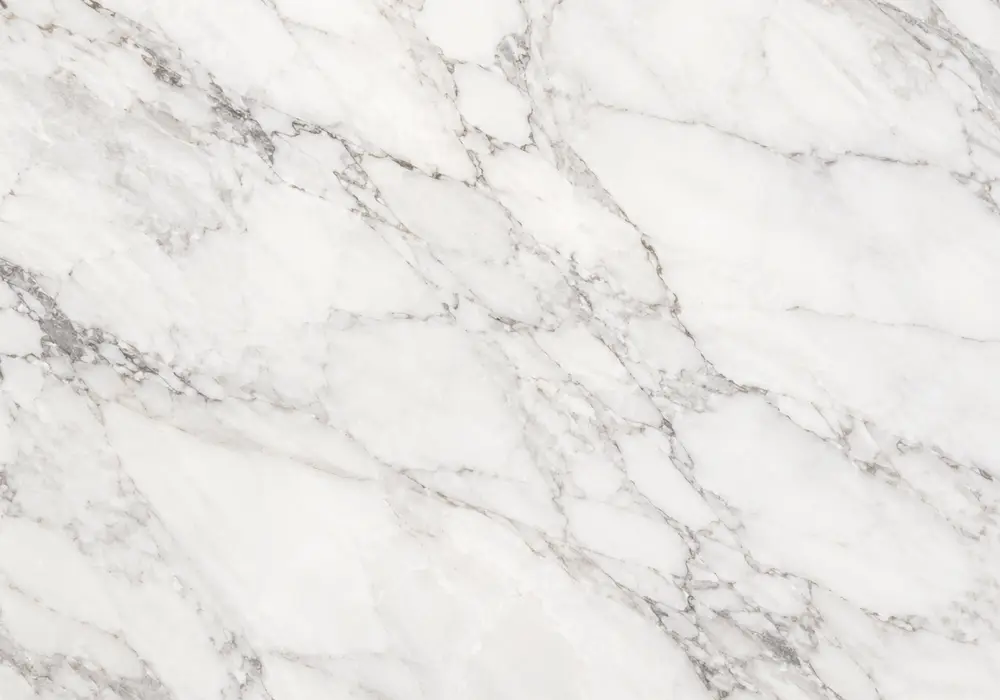 polished Pietra Grey slab beside a honed vanity and textured exterior sample, showing fine white veins and subtle wear marks.