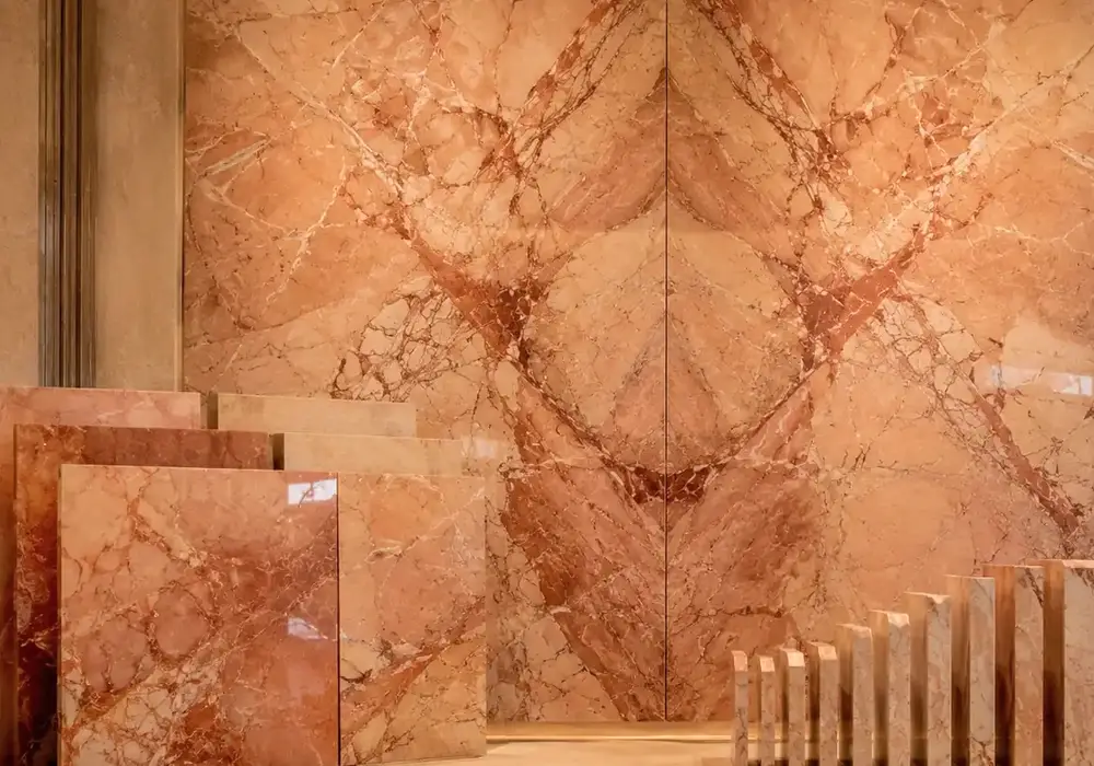 Rosa Valencia flooring in polished peach-gold stone with honed stairs, wall cladding, kitchen surface and bathroom vanity.