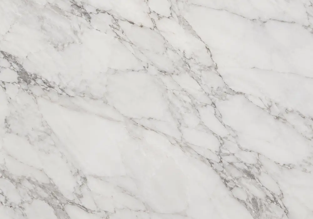 Staturio countertop on polished kitchen island with vanity, honed floor and feature wall, showing controlled grey veins.