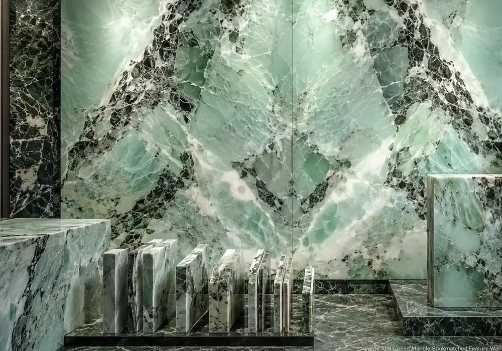 polished green slabs paired with honed lobby stairs and wall panels, showing dense white calcite in a sheltered interior.