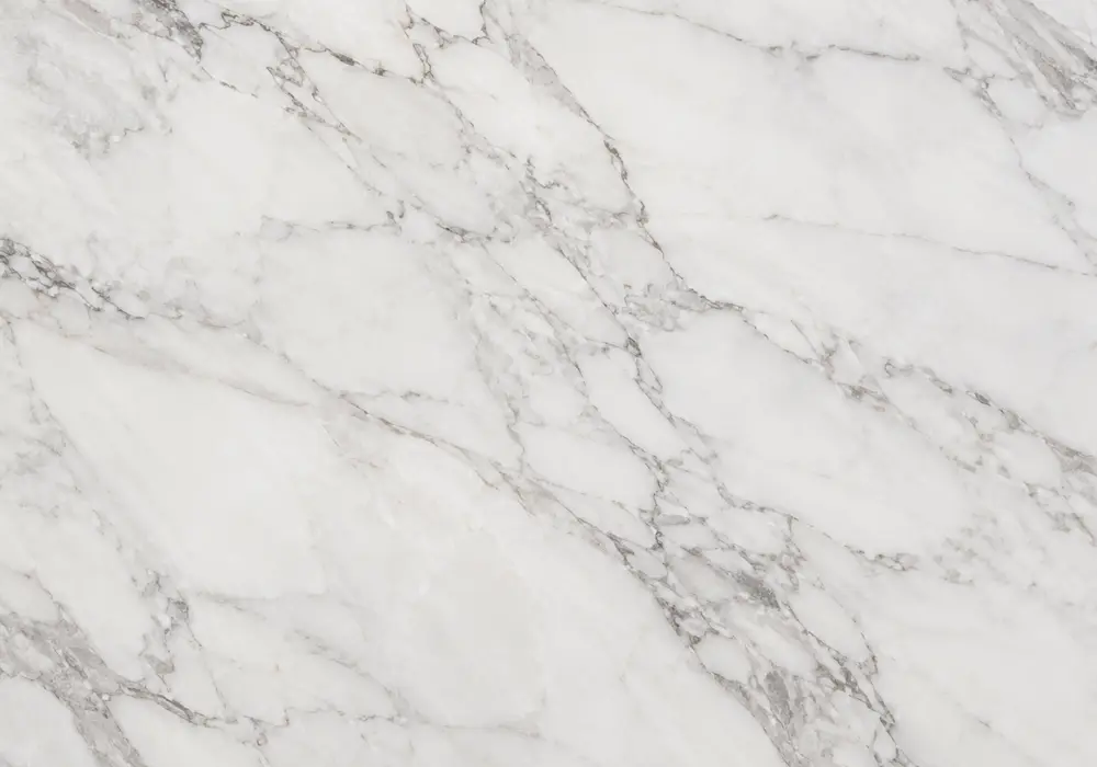 Statuario stone slabs and large tiles in polished, honed and textured finishes displayed in a bright premium stone showroom.